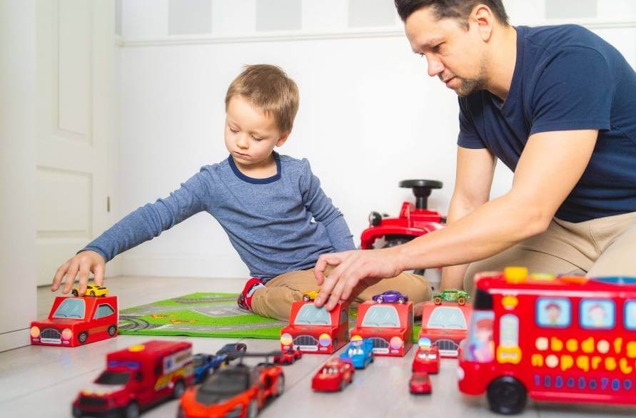 Dad and Son playing with cars and wearing colourful socks